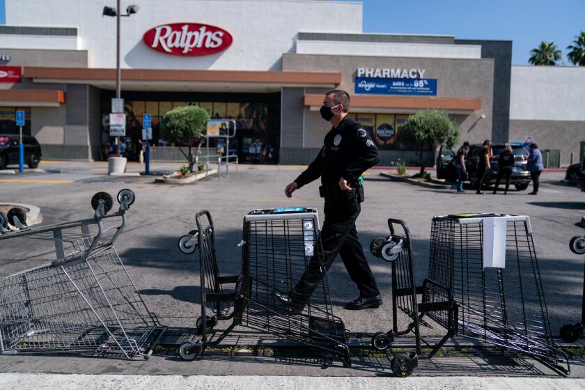 LOS ANGELES, CA - MAY 01: Carts block the entrance to the parking lot of a Ralph's grocery store as grocery store workers along with UFCW 770 representatives and community members hold a social distancing rally at the Hollywood Ralph's on Friday, May 1, 2020 in Los Angeles, CA. Workers at the Ralph's on Sunset have said that 19 employees have tested positive for COVID-19/Coronavirus and they are protesting working conditions for frontline/essential workers. (Kent Nishimura / Los Angeles Times)