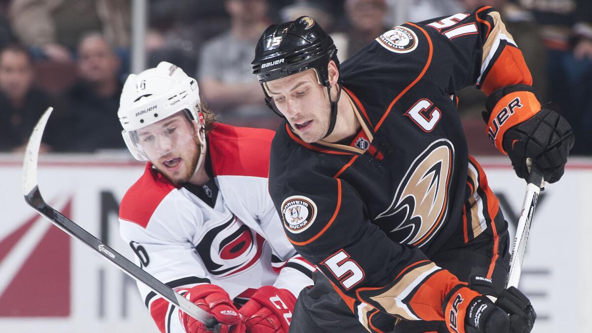 Ducks captain Ryan Getzlaf (15) controls the puck in front of Carolina Hurricanes center Elias Lindholm during the Ducks' 5-4 victory at Honda Center on Feb. 3.