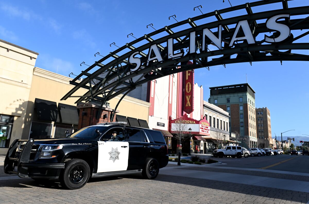A police vehicle drives under a sign in downtown Salinas. 