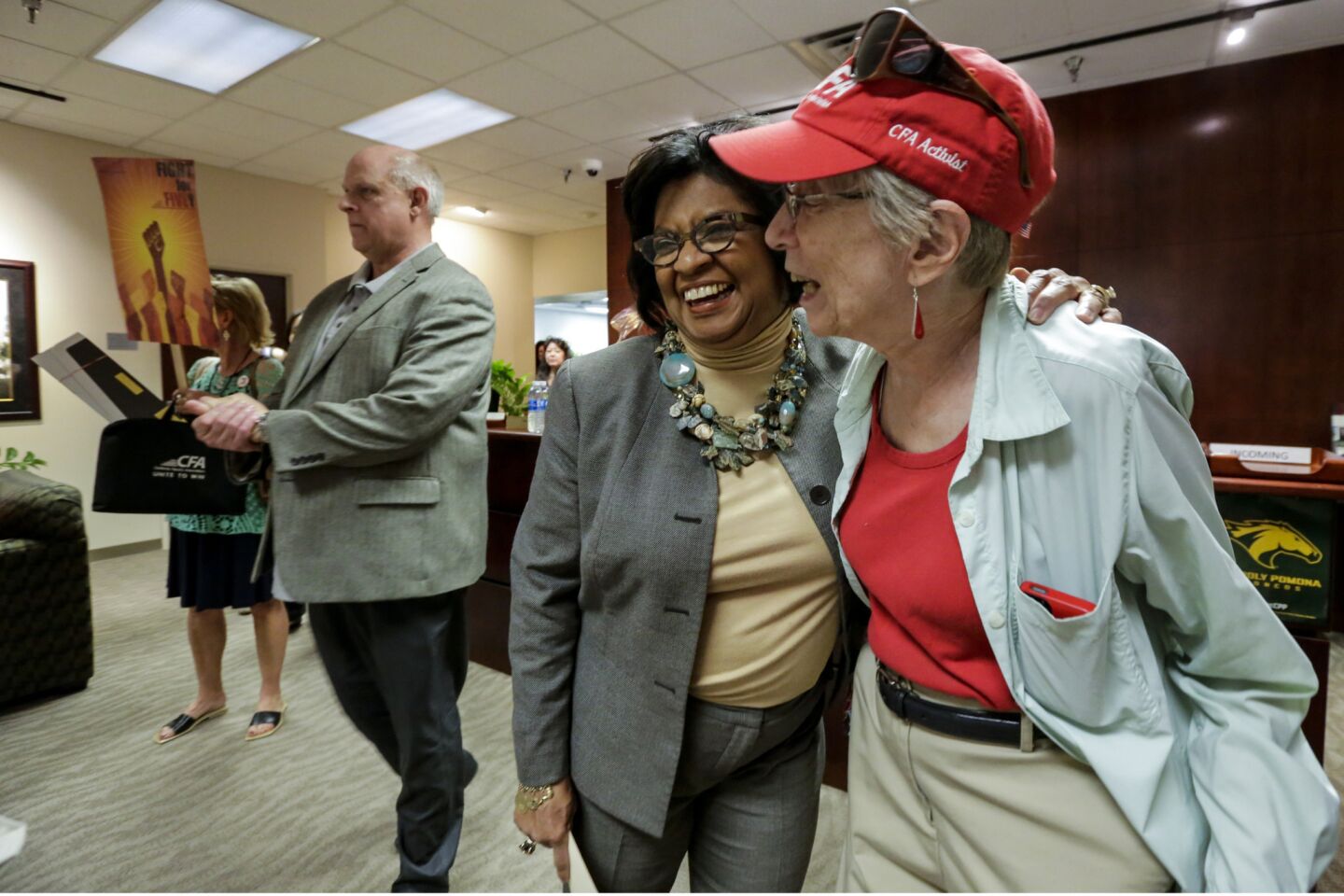 Cal Poly Pomona President Soraya Coley, left, hugs retired mathematics professor Harriet Lord, who marched with other faculty to Coley's office Tuesday.
