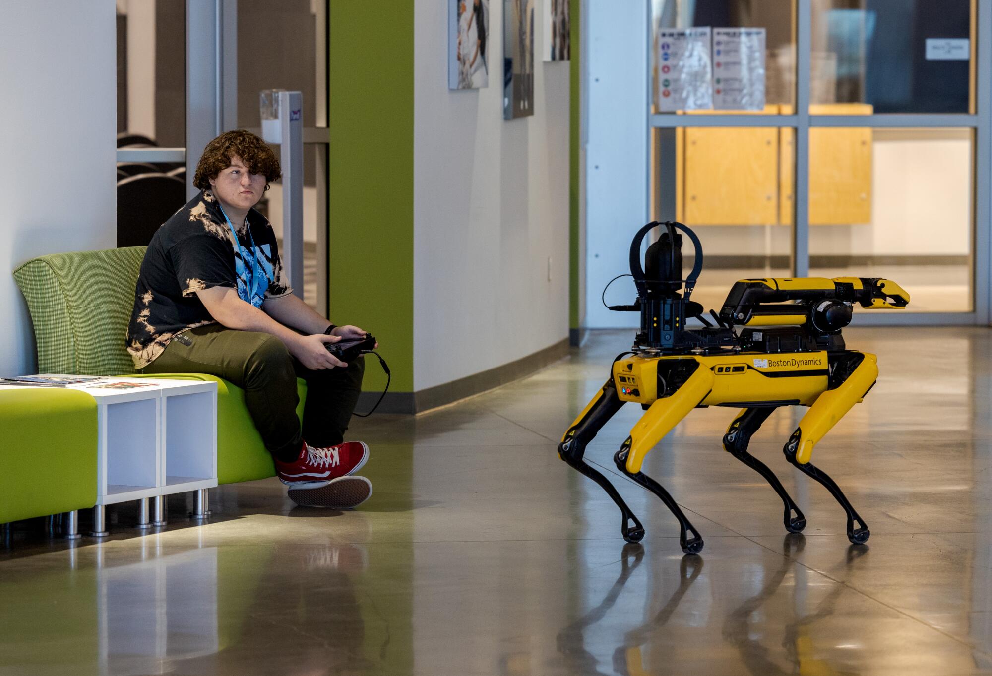 Senior Peyton Finney operates a yellow and black robotic dog.