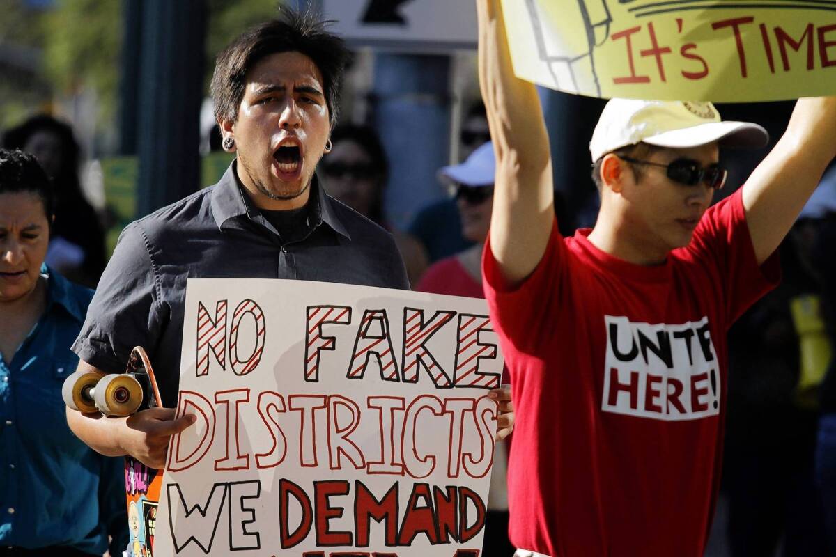 Anaheim resident Jesse Murillo, left, was among about 50 people protesting Anaheim's council election plan July 23. The council approved a requirement that members live in specific districts but did not change at-large voting.