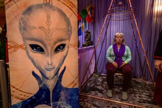 LOS ANGELES, CA-February 9, 2024: Carol Chappell, from Sedona, Arizona, sits inside a pyramid known as a multi dimensional healing chamber enhanced by tensor rings on display at the Conscious Life Expo at the LAX Hilton Hotel in Los Angeles. (Mel Melcon / Los Angeles Times)