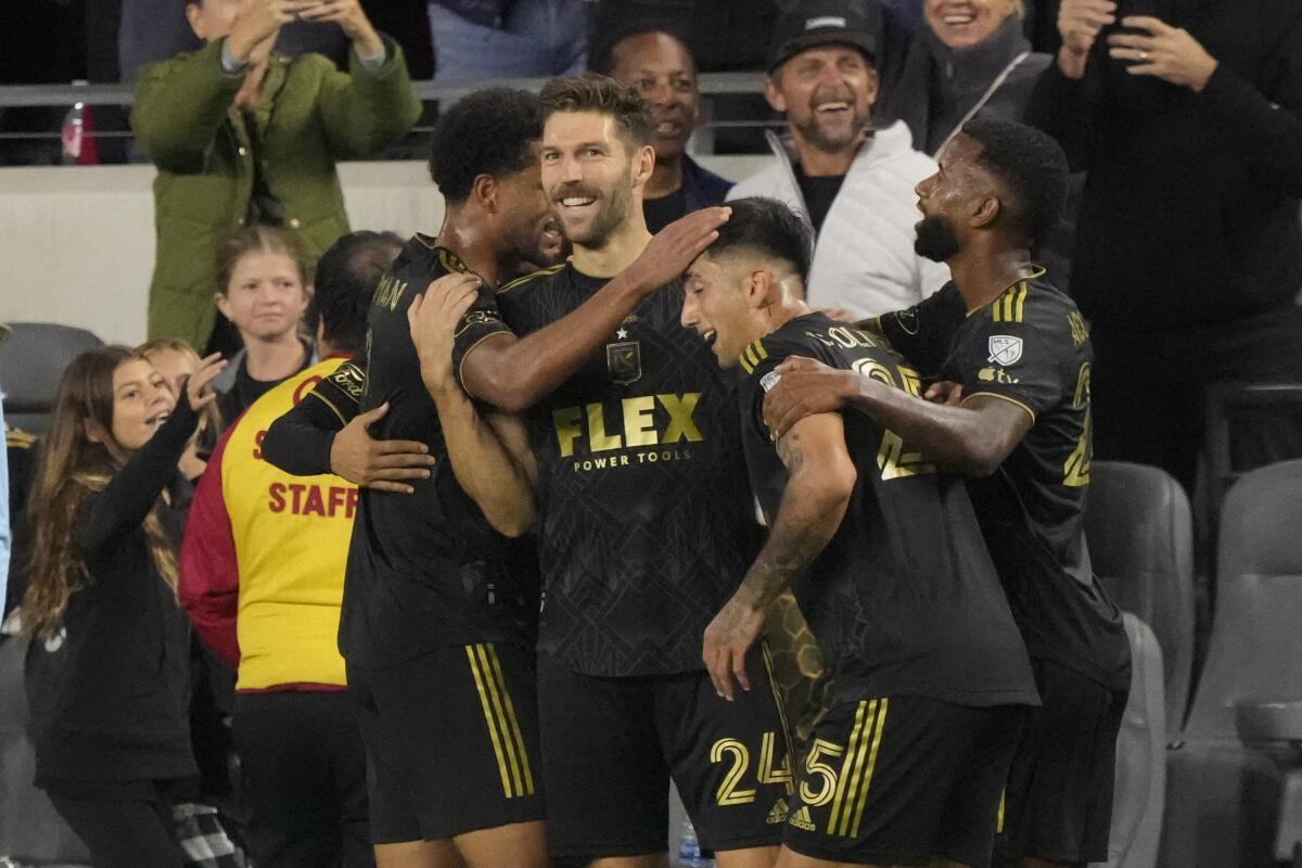 LAFC Ryan Hollingshead, center, celebrates with teammates after scoring in the first half Saturday.