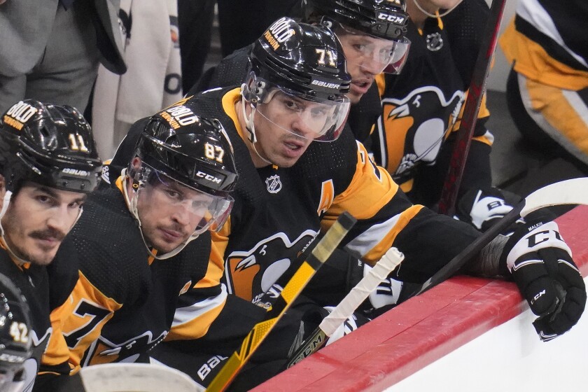 Pittsburgh Penguins' Sidney Crosby (87) and Evgeni Malkin (71) sit on the bench during the third period of an NHL hockey game against the Columbus Blue Jackets in Pittsburgh, Friday, April 29, 2022. (AP Photo/Gene J. Puskar)
