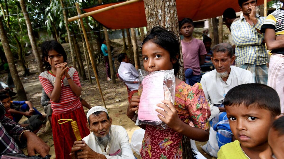 Rohingya children wait for their parents to receive aid earlier this month at the Balukhali food distribution center near the town of Cox's Bazar, Bangladesh. More than 646,000 Rohingya refugees have crossed the border from Myanmar into Bangladesh.