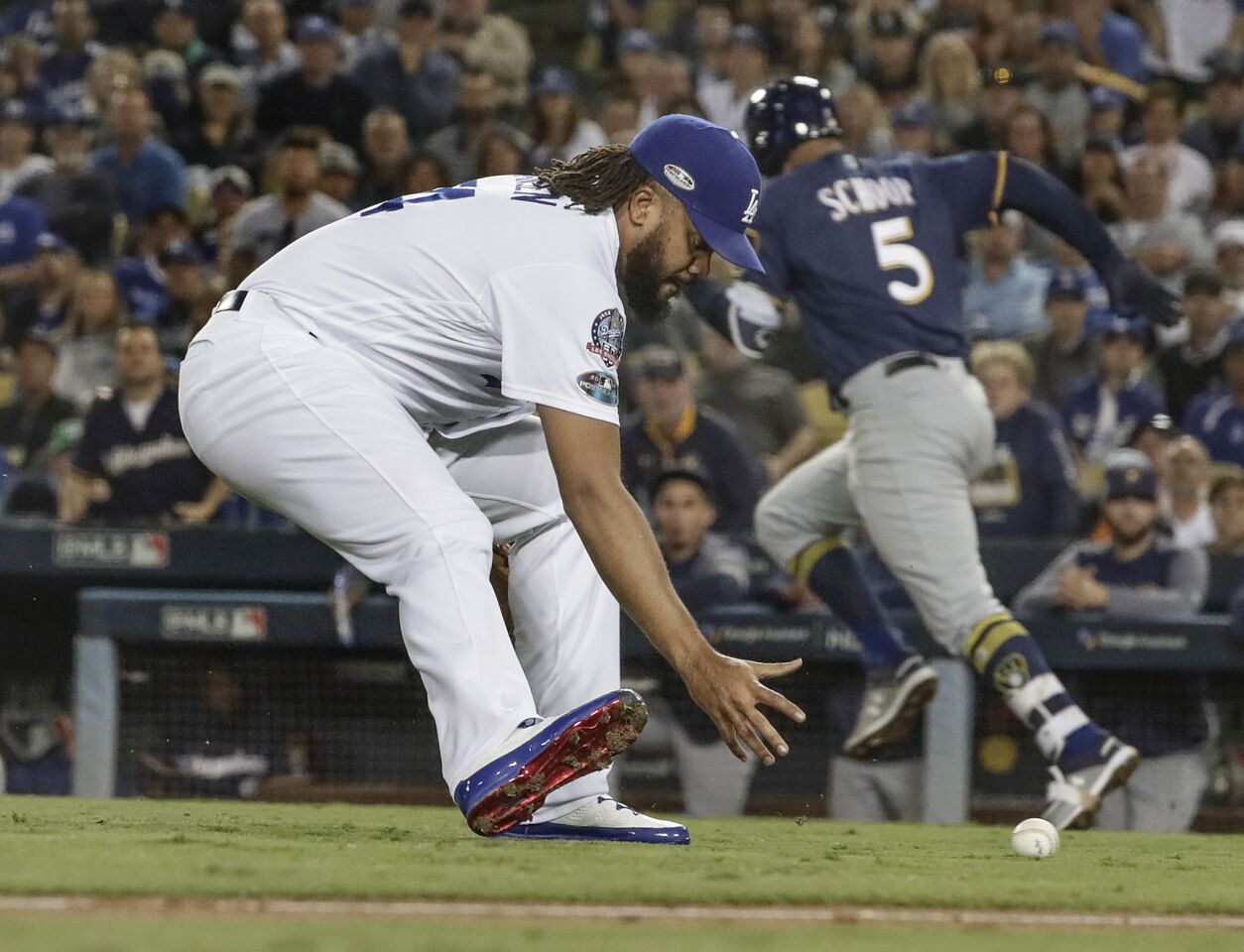 Dodgers pitcher Kenley Jansen rushes to field a short hit ball and throw out Brewers second baseman Jonathan Schoop in the ninth inning.