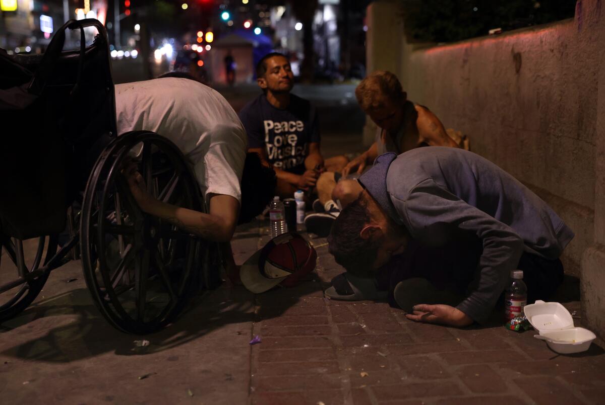 Los Angeles, CA - September 10: People gather around while some fall over from the aftermath of smoking 