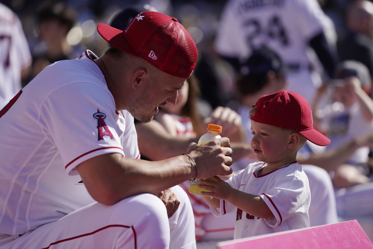 Angels star Mike Trout talks to his son before the MLB Home Run Derby at the All-Star Game on Monday.