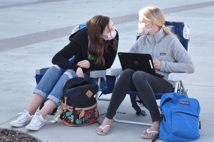 Oak Valley Middle School eighth graders Nora Mauseth and Ava Christiansen were among students who gathered at Del Norte High for a sit-in to protest virtual learning.
