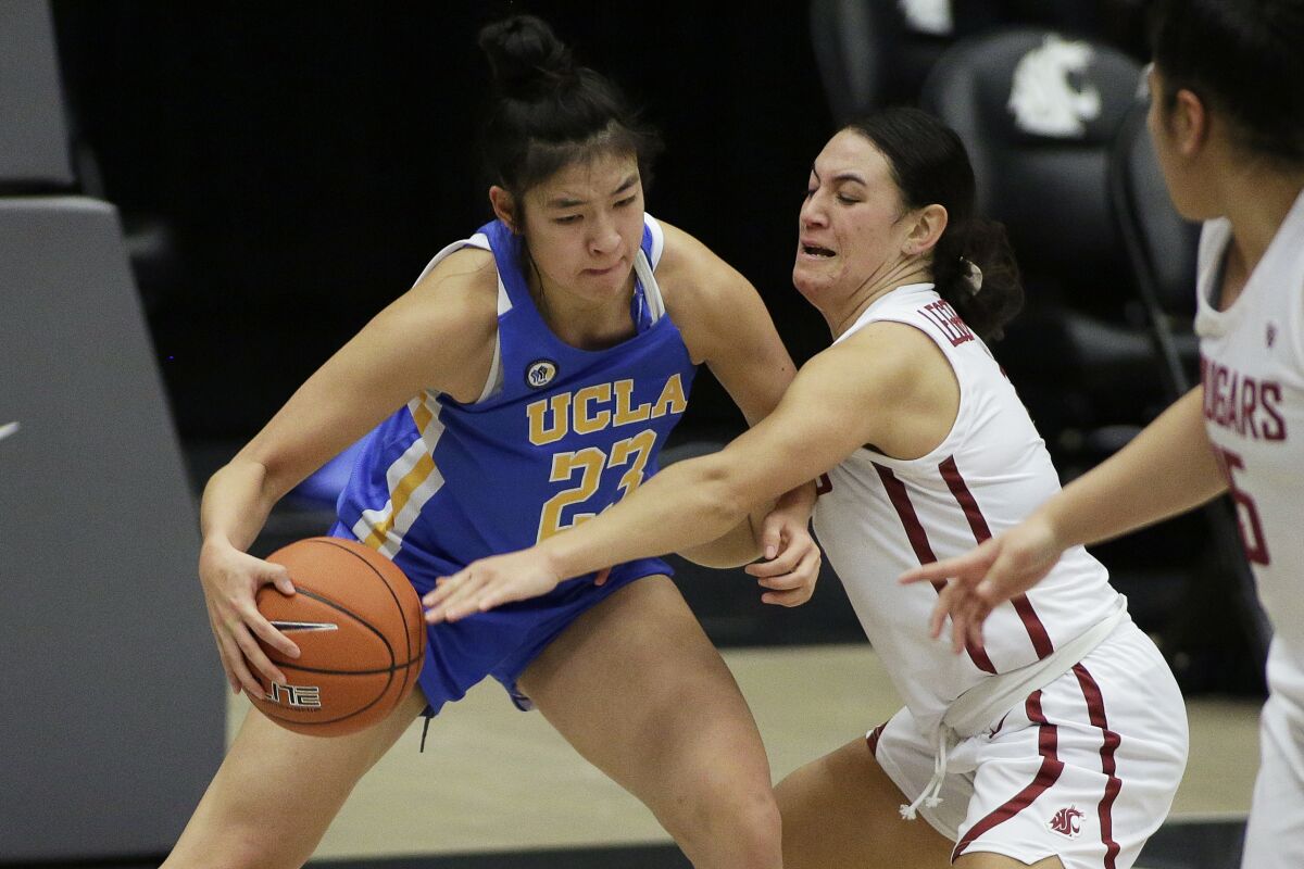 UCLA guard Natalie Chou, left, is pressured by Washington State guard Krystal Leger-Walker during a game on Feb. 5.