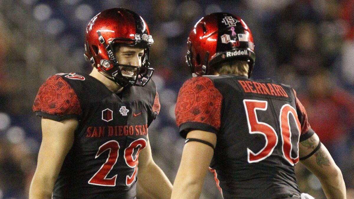 San Diego State place-kicker John Baron II (left) celebrates with long snapper Turner Bernard after Baron kicked a 51-yard field goal with 4:36 remaining against San Jose State at SDCCU Stadium. The field goal provided the winning points.