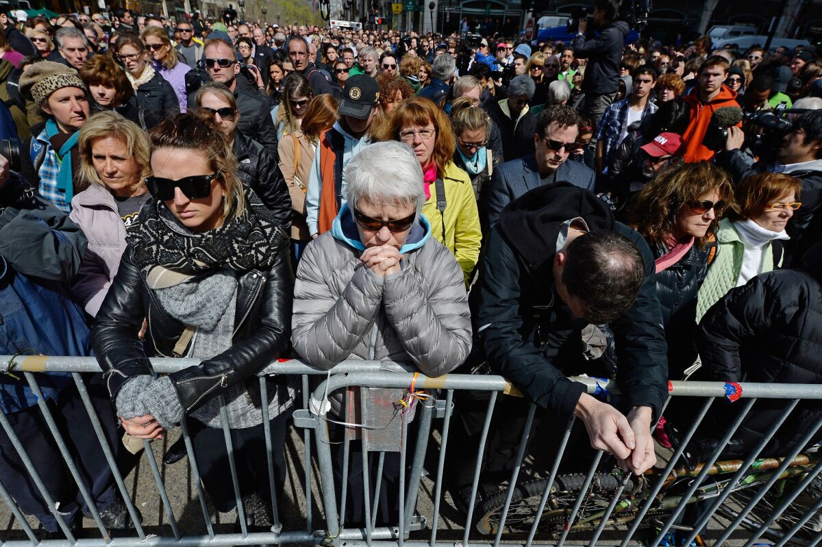 People observe a moment of silence near the Boston Marathon finish line on the one-week anniversary of the bombings.