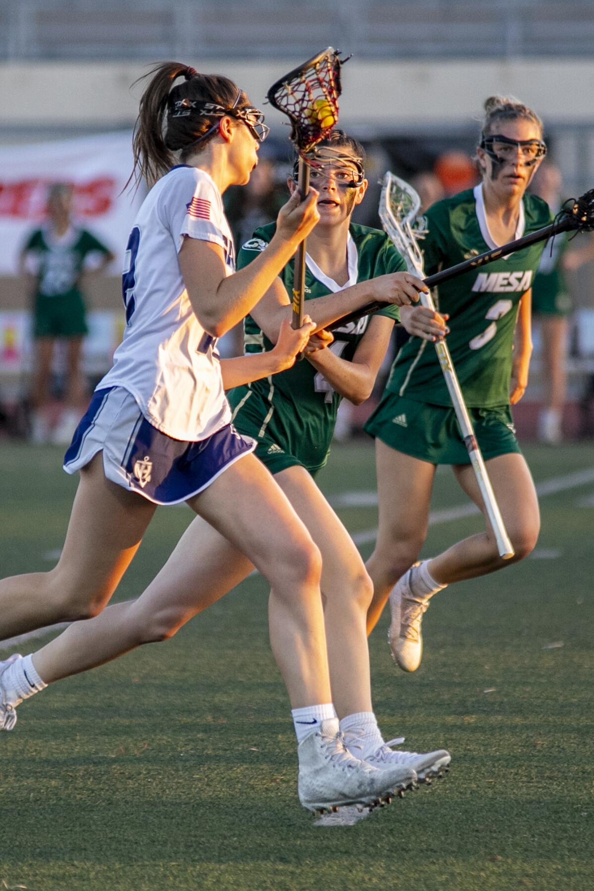 Newport Harbor's Lauren Boyd runs with the ball, defended by Murrieta Mesa's Jayda Johnson and Carson Dickey.