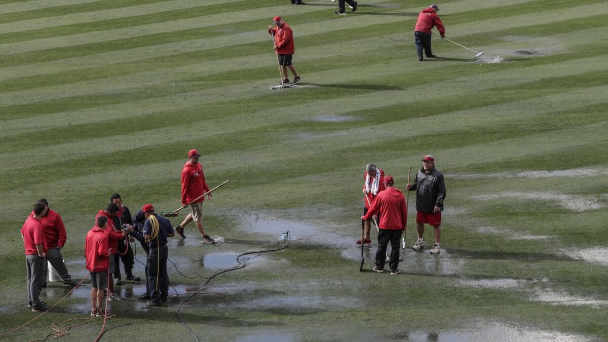 The Angel Stadium grounds crew tries to get rid of rain water on the field before Wednesday's game between the Angels and Minnesota Twins was postponed. The Angels had hoped to get a day off Thursday but the Twins wanted to make up the rainout immediately.