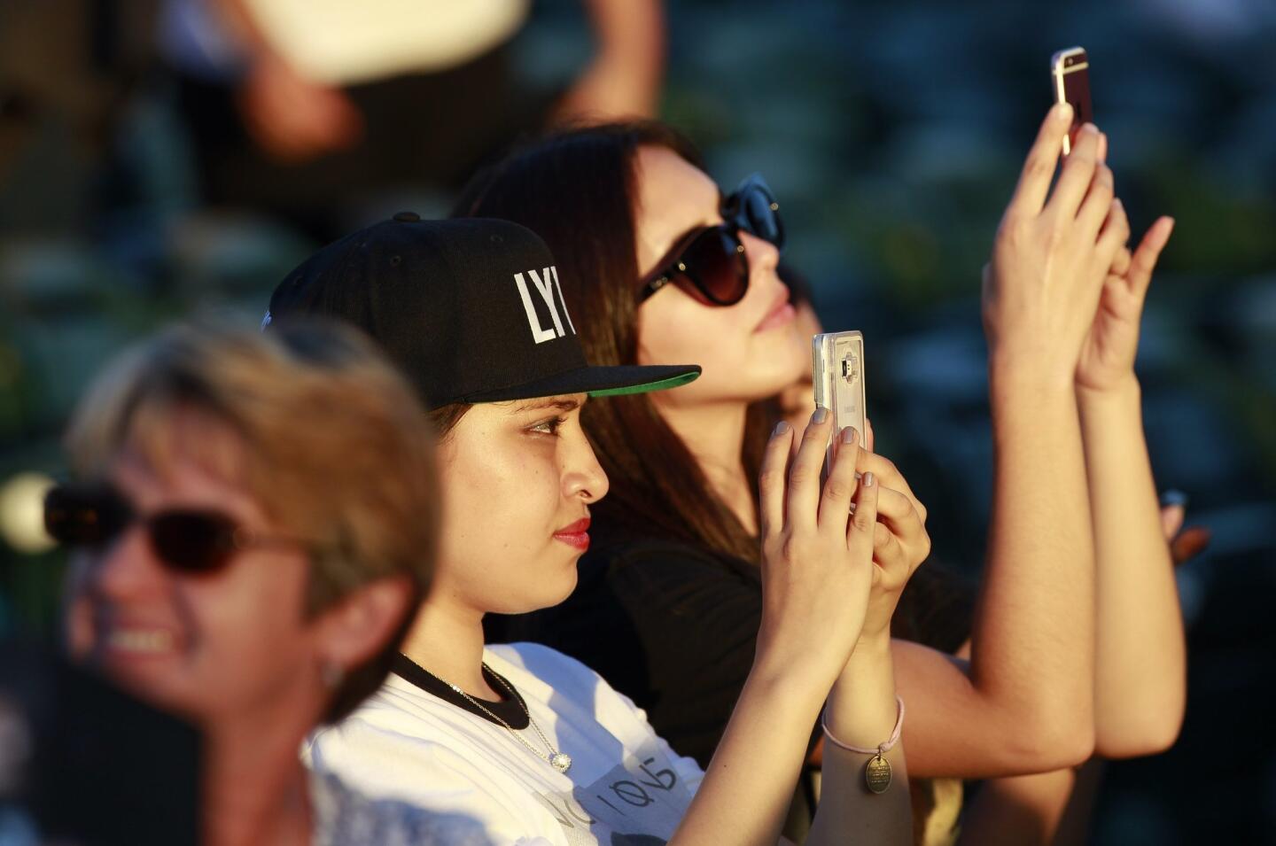 Fans use their phones to record Chord Overstreet performing before Nick Jonas and Demi Lovato.