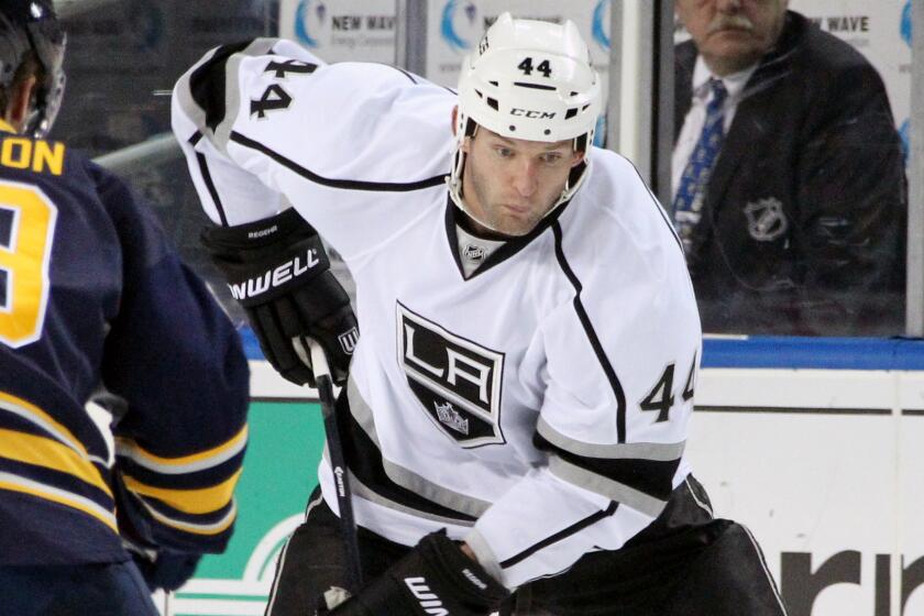 Kings defenseman Robyn Regehr, right, controls the puck during a game against the Buffalo Sabres on Dec. 9.