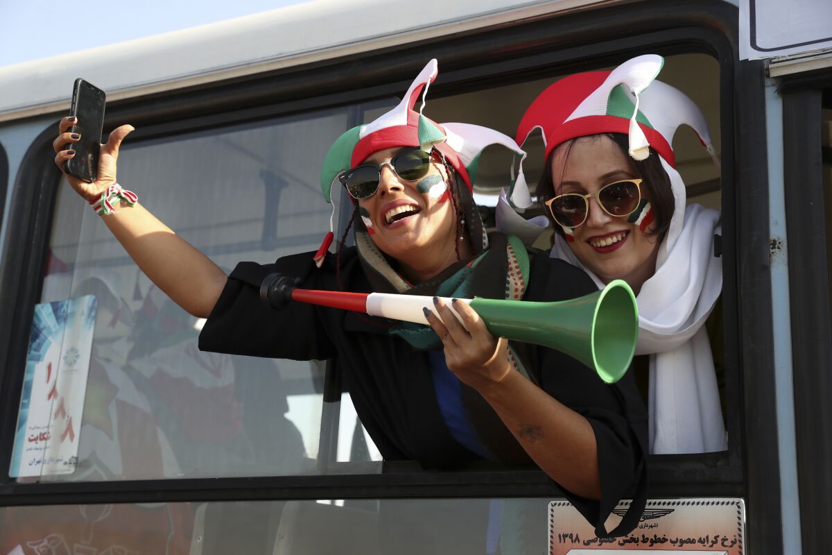 Iranian women cheer as they arrive to the Azadi Stadium