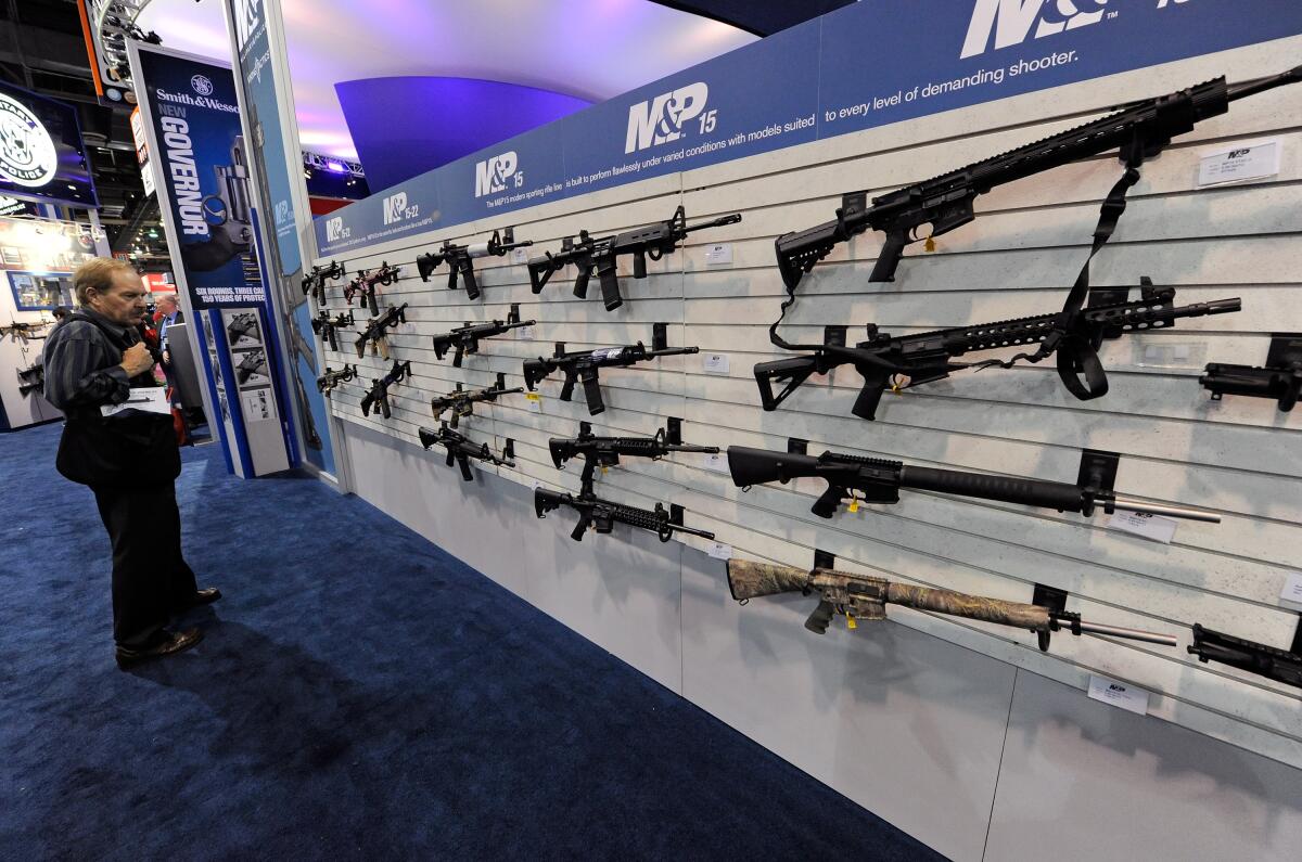 An attendee looks at Smith & Wesson M&P15 rifles at the Smith & Wesson booth at a Vegas trade show