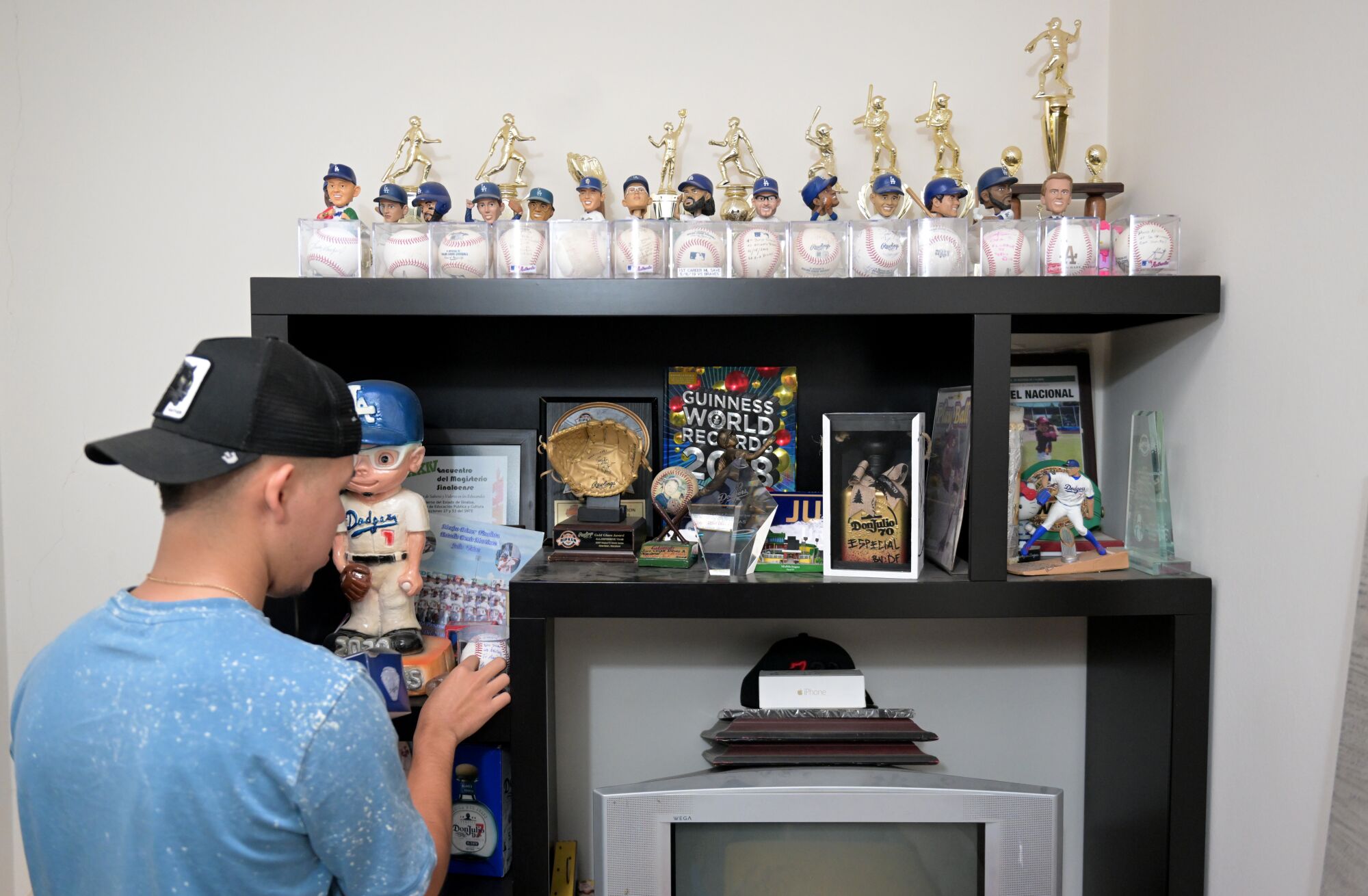 Carlos Urías Jr. looks at memorabilia of his brother, Dodgers pitcher Julio Urías.