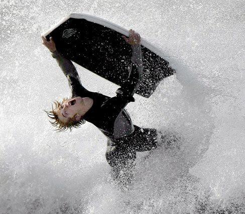 A body-boarder launches off a big wave on the south side of the Seal Beach pier, where heavy surf has forced the closure of that city's pier. The Manhattan Beach pier was also closed, and search-and-rescue teams continue to look for a person swept off the rocks in Rancho Palos Verdes on Sunday evening.
