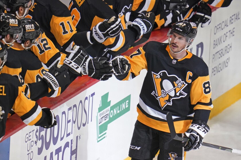 Pittsburgh Penguins' Sidney Crosby (87) returns to the bench after scoring during the third period of an NHL hockey game against the Montreal Canadiens in Pittsburgh, Saturday, Nov. 27, 2021. (AP Photo/Gene J. Puskar)