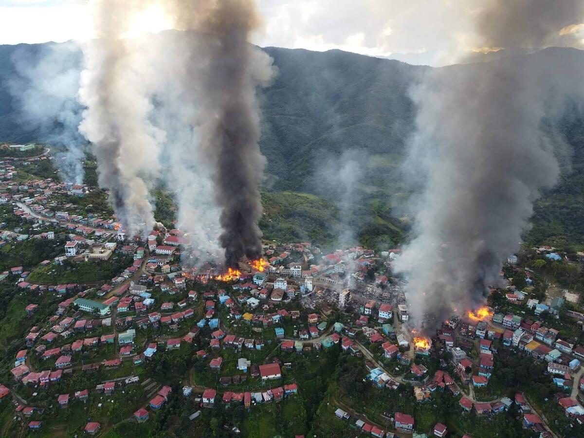 A view from overhead shows smoke rising from multiple fires in buildings  