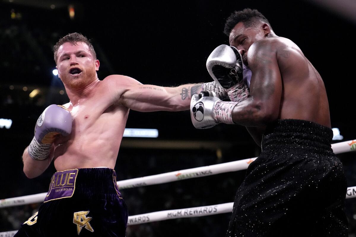 Canelo Álvarez, left, punches Jermell Charlo during their super middleweight title fight at T-Mobile Arena on Saturday.