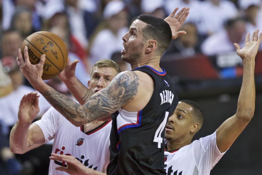 Clippers guard J.J. Redick, center, shoots in front of Portland Trail Blazers center Mason Plumlee, left, and guard C.J. McCollum, right, during the first half of Game 3 of the Western Conference playoff on Saturday.