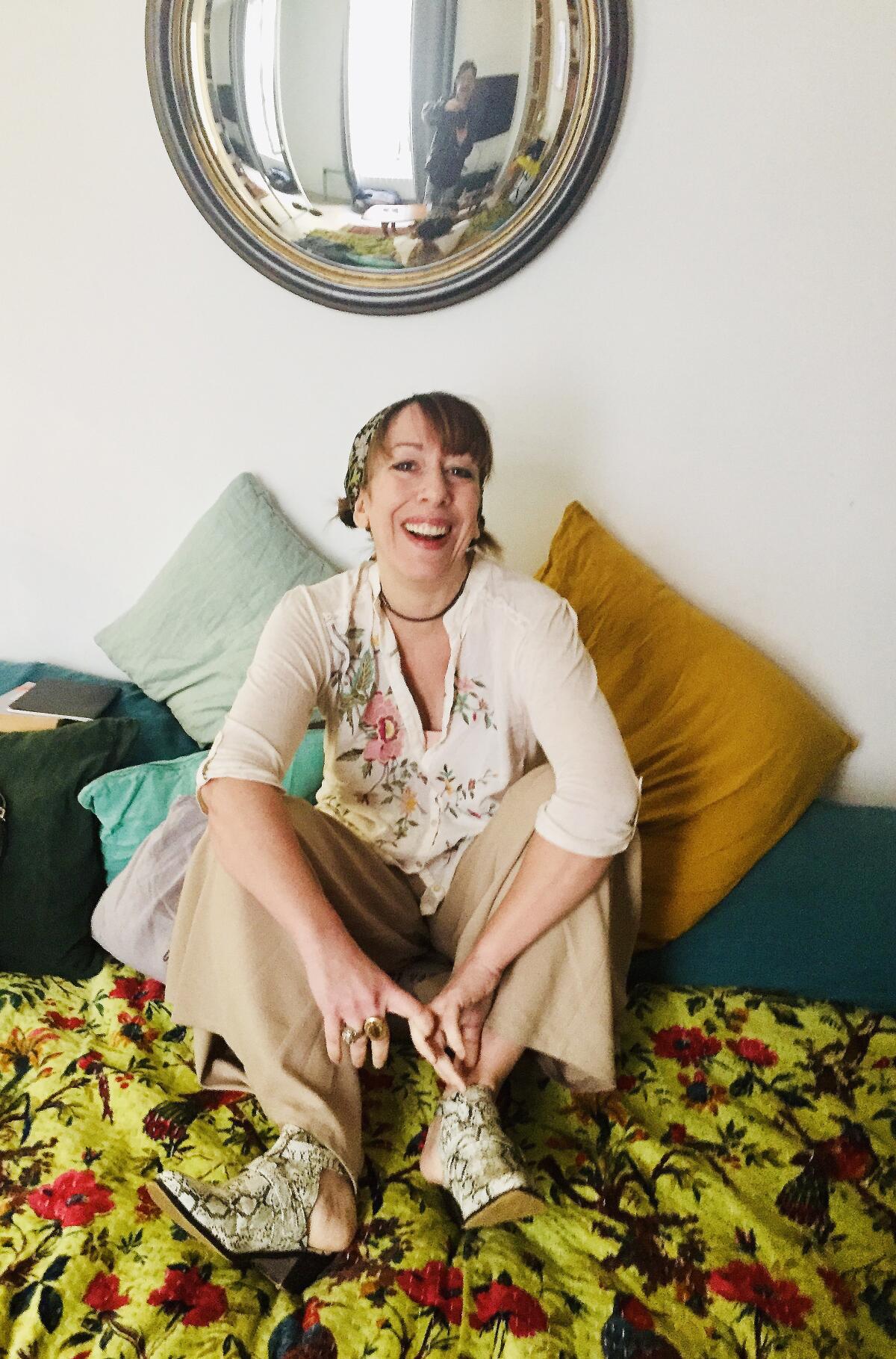 "Blow Your House Down" memoirist Gina Frangello sits on a bed
