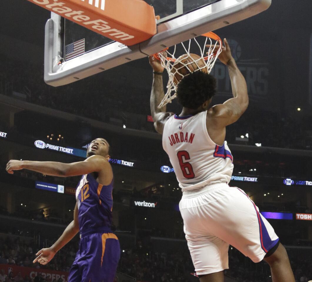 Clippers center DeAndre Jordan finishes off an alley-oop reverse dunk against Suns forward T.J. Warren in the first half.