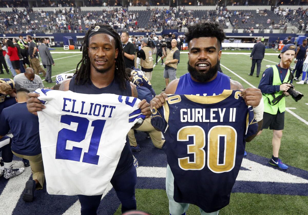 Los Angeles Rams' Todd Gurley, left, and Dallas Cowboys' Ezekiel Elliott, right, swap jerseys after an NFL football game, in Arlington, Texas. Gurley is a big football fan, and Elliott is one of his favorite players. The good feelings are mutual heading into the Cowboys' playoff visit to the Rams and a showdown between the NFL's two premiere running backs.