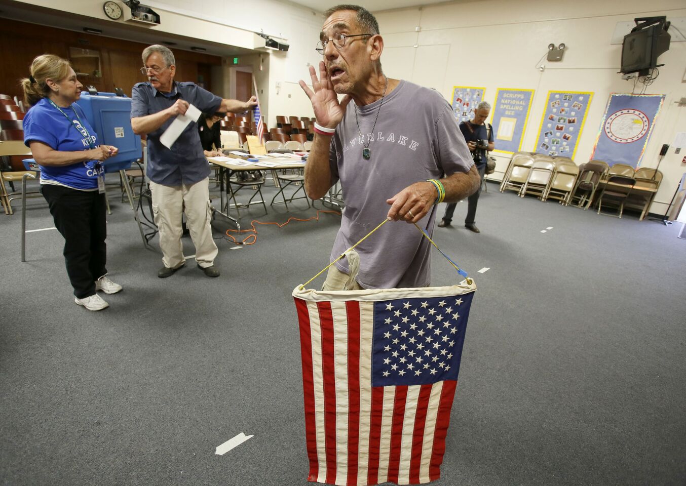 Where to hang the flag? Poll workers Esperanza Gaytan, left, Mathew Klempa and Barry Copilow, holding the flag, try to decide on the right spot at Allesandro Elementary School in Silver Lake.