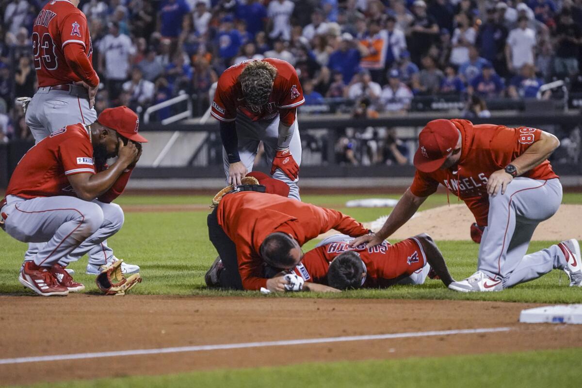 Angels starting pitcher Chase Silseth, lays on the ground after getting hit with a throw.