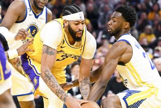  The Warriors' Andrew Wiggins tries to poke the ball away from Los Angeles Lakers forward Anthony Davis during Game 5