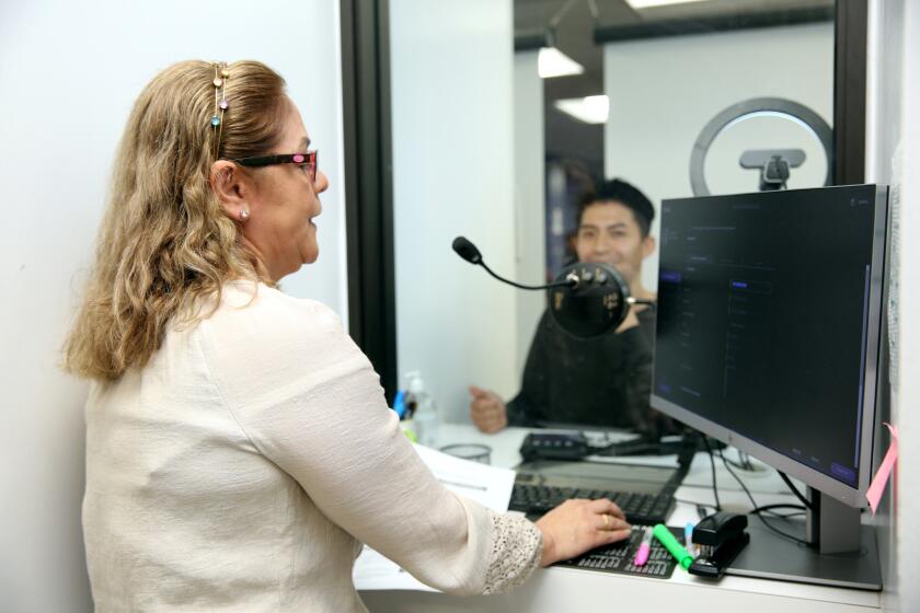Consul agent Nilda Diaz helps a Honduran national at the Honduras consulate in Los Angeles on Friday, March 31, 2023.