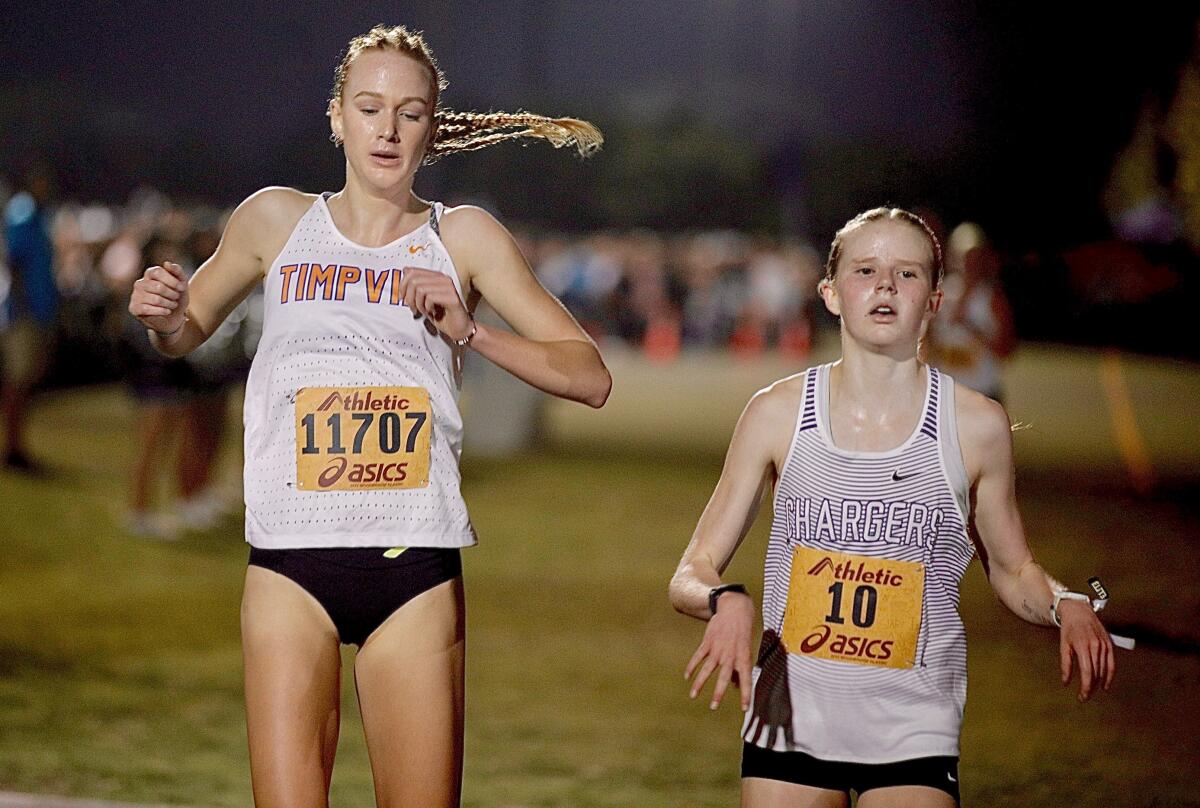 Two girls compete in a cross country race 