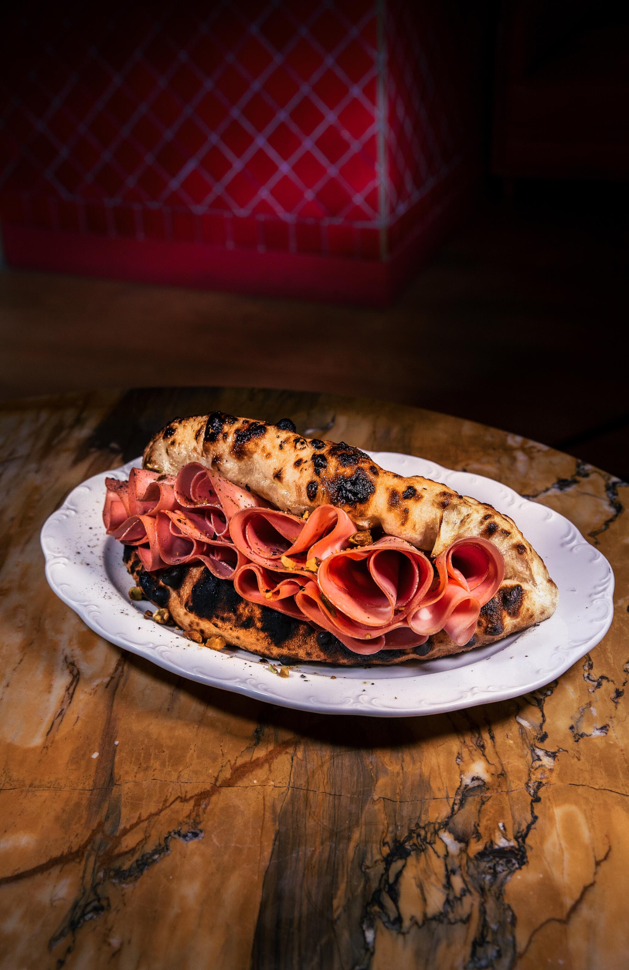 La Mortazza, a folded-over pizza sandwich with mortadella peeking out at the edges.
