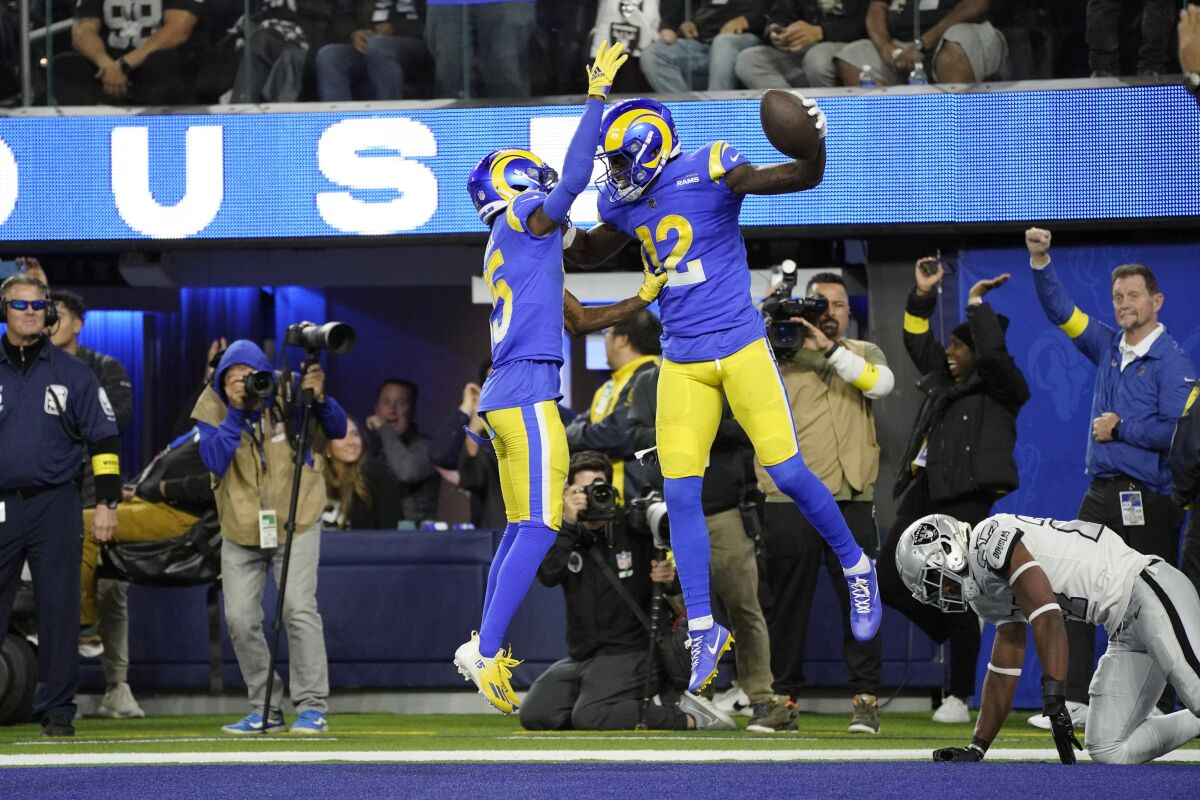 Los Angeles Rams wide receiver Van Jefferson (12) celebrates his touchdown with teammate wide receiver Tutu Atwell as Las Vegas Raiders cornerback Sam Webb, right, gets up during the second half of an NFL football game Thursday, Dec. 8, 2022, in Inglewood, Calif. (AP Photo/Mark J. Terrill)