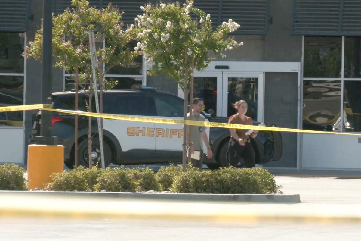 A sheriff's vehicle and yellow caution tape outside a Walmart in Lake Elsinore.