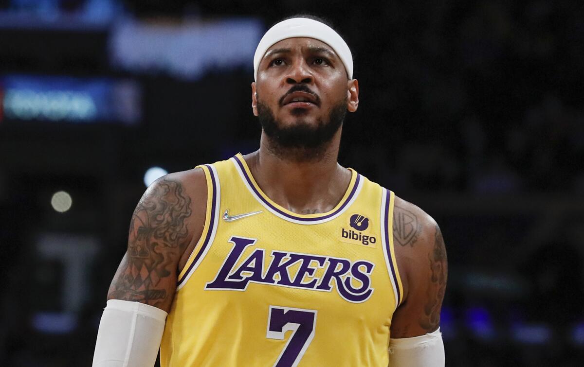 Lakers forward Carmelo Anthony stands on court in uniform during a break.