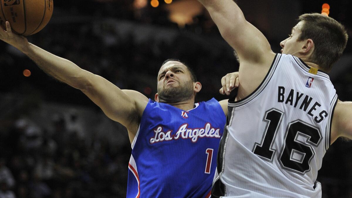 Clippers guard Jordan Farmar, left, shoots over San Antonio Spurs forward Aron Baynes during the Clippers' 125-118 loss Dec. 22.