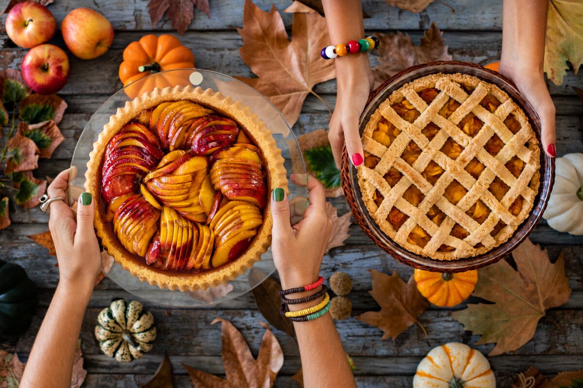 Overhead view of an apple pie, a pumpkin pie and a peach pie.