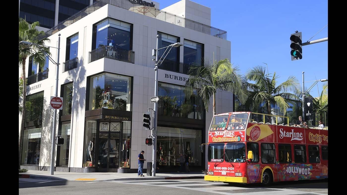 A double-deck tour bus cruises past the new three-story home of Burberry on Rodeo Drive in Beverly Hills. The newly constructed building has a VIP entrance and dedicated parking.