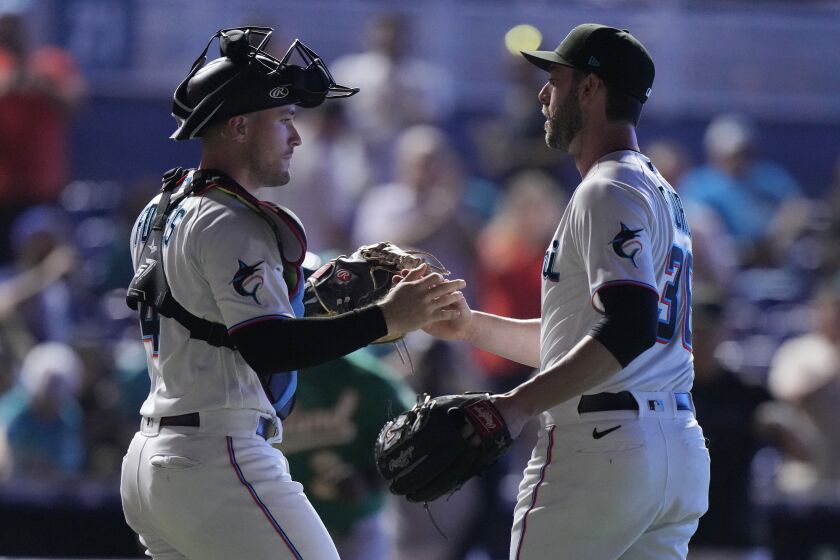 Miami Marlins catcher Nick Fortes, left, and relief pitcher Dylan Floro congratulate each other after the Marlins beat the Oakland Athletics 7-5 during a baseball game, Sunday, June 4, 2023, in Miami. (AP Photo/Wilfredo Lee)