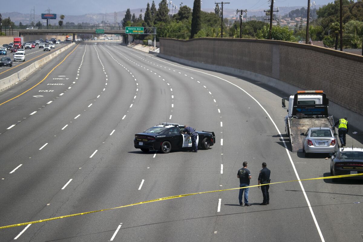 Crime scene investigators secure the northbound lanes of the 55 Freeway after road rage incident May 21 in Orange