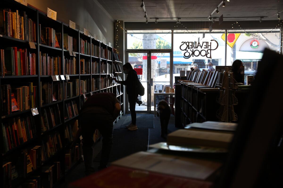 A shopper browses at Chevalier's Books in Larchmont on Saturday, Nov. 28, with customers limited to six at a time.
