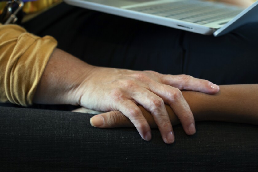 Nurse Elsa Harmon comforts patient Perla Fuentes.