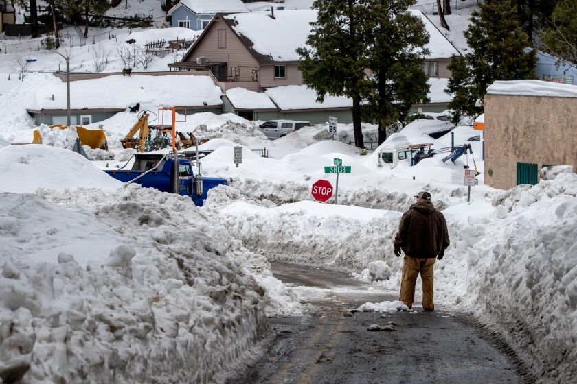 CRESTLINE, CA - MARCH 6, 2023: Crestline Road is down to one lane as piles of snow stack up on both sides of the road off Highway 138 on March 6, 2023 in Crestline, California. (Gina Ferazzi / Los Angeles Times)