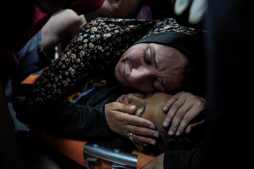Una mujer palestina llora a su hijo, Mahmoud Essa, de 12 años, asesinado por el bombardeo israelí de la Franja de Gaza, en el Hospital de Al Aqsa en Deir al Balah, en la Franja de Gaza, la madrugada del domingo 12 de mayo de 2024. (AP Foto/Saher Alghorra)
